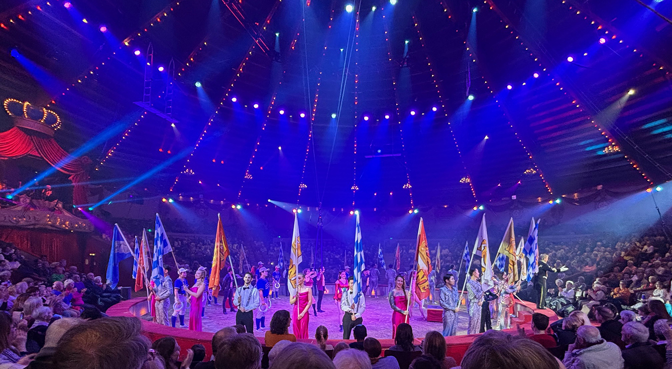 die Artisten in der manege mit bunten, großen Fahnen