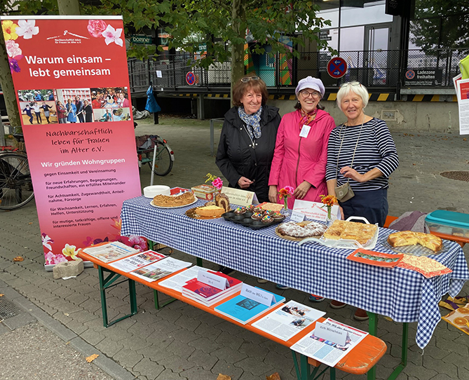3 Wohnfrauen mit großer Kuchenauswahl und Infomaterial