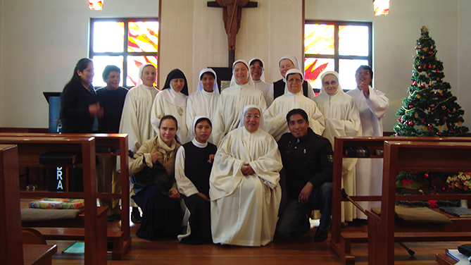 Bild in der Kirche mit Schwestern in weisser Tracht und Mitarbeitern 