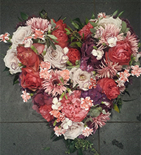 Ein Blumenherz aus rot und rosafarbenen Blumen