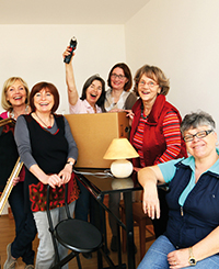 6 fröhliche Frauen feiern den Einzug in die neue Wohngruppe zwischen pappkartons