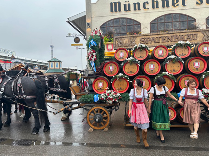 Das Pferdegespann mit den Bierfässern vom Spatenbräu und 3 feschen Madln im Dirndl