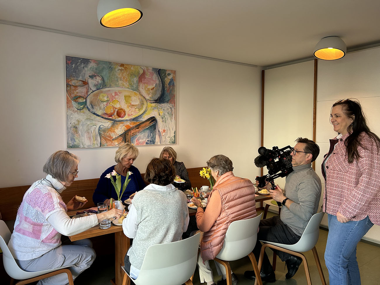 WG V, 5 Frauen am Frühstückstisch mit Kameramann und Interviewerin