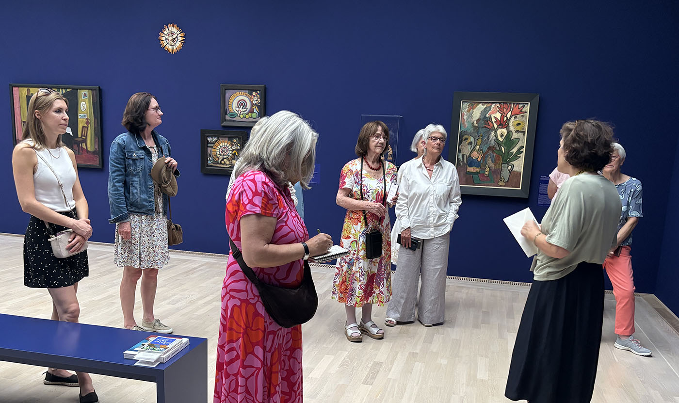Die Gruppe mit der Kunstvermittlerin im ersten blauen Raum vor Werken der Künstlerin Gabriele Münter
