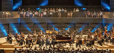 Blick auf die Bühne der Isarphilharmonie mit Orchester und Flügel