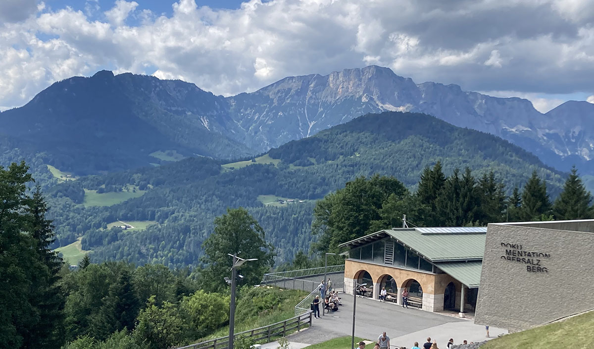 Blick auf das Dokumetationszentrum, im Hintergrund Berge und Wolken