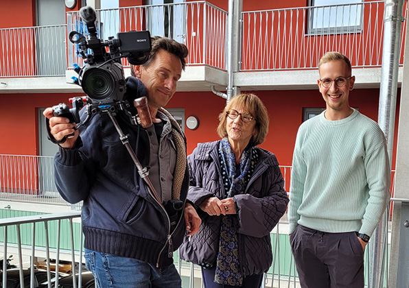 Christa Lippmann im Gespräch mit 2 Kameraleuten von RTL im Laubengang von WG 6