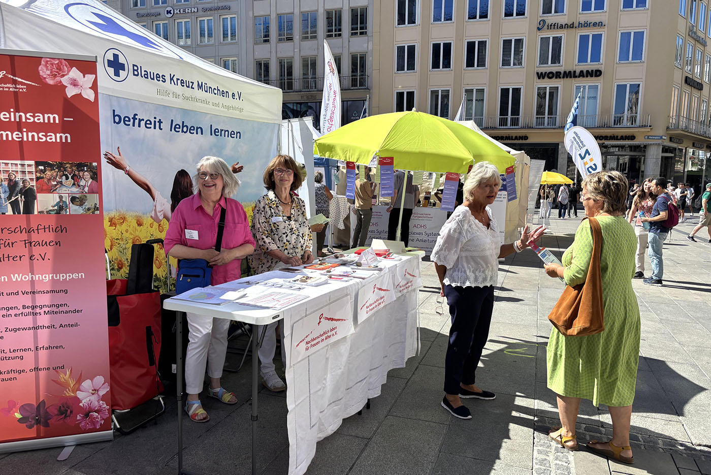 3 Frauen am Stand bei der Beratung einer interessierten Frau