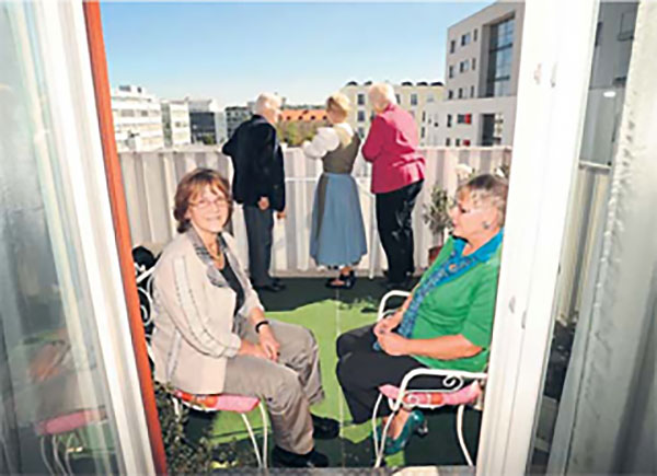 Wohnfrauen blicken vom Balkon auf Wohnanlage