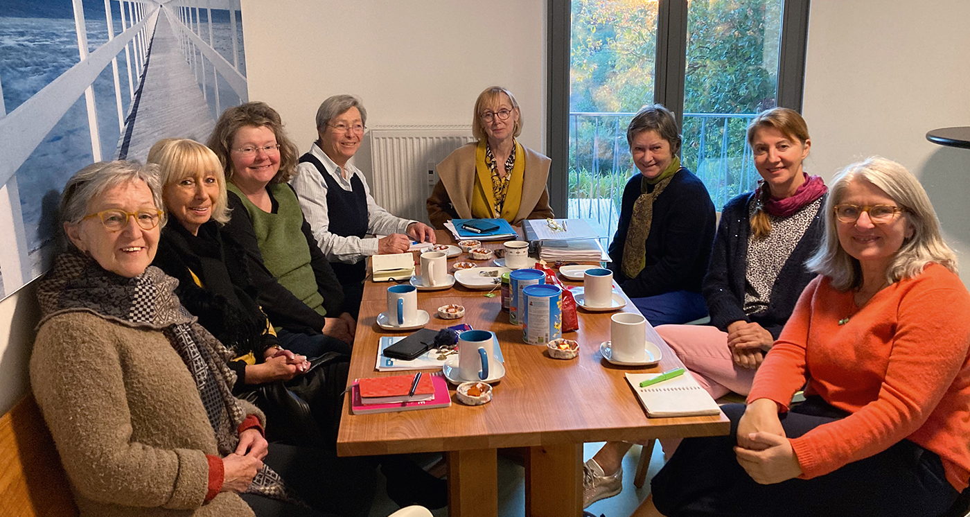 Gemeinschaftsraum WG 6: Die 8 Wohnfrauen bei einer Gruppenbesprechung mit Kaffee und Kuchen im Gemeinschaftsraum